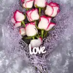 Bouquet de roses rouges et blanches avec une lettre d'amour