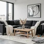 Salon familial décoré en noir gris blanc avec canapé en lin gris anthracite, coussins blancs et panier rangement jouets